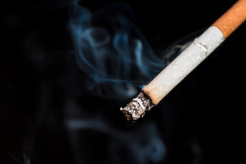 Burning cigarette with smoke and concept of cigarettes 