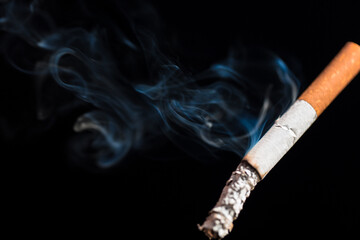 Burning cigarette with smoke and concept of cigarettes 