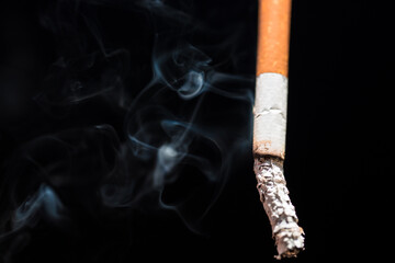 Burning cigarette with smoke and concept of cigarettes 