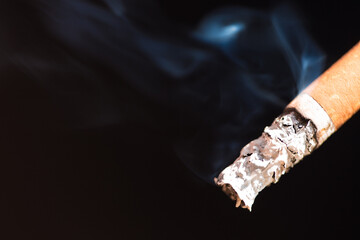 Burning cigarette with smoke and concept of cigarettes 