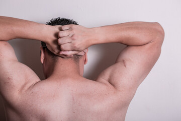 A person with no shirt with hands on head like getting arrested