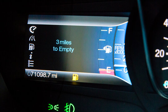 Gauge showing low fuel levels on a modern car - Powered by Adobe