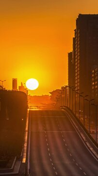 Time-lapse footage of the sun slowly rising over Fuxingmenwai Street in Beijing, China in the early morning