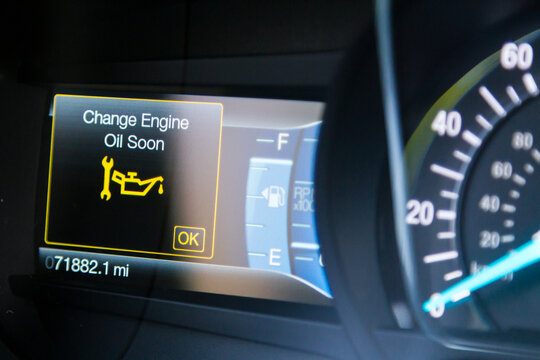 Car dashboard of a car needing an oil change showing a warning light