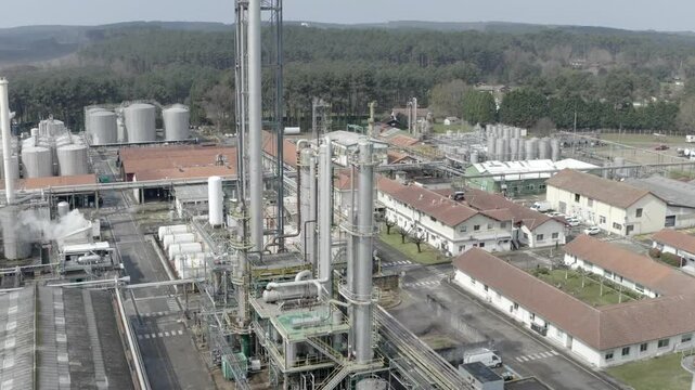 Drone footage flying above a large industrial factory complex in Veille Saint Girons, showcasing manufacturing, pipes, and smokestacks, France