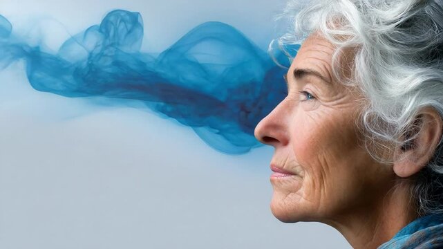 Elderly Caucasian woman with white hair gazes thoughtfully as blue smoke swirls, symbolizing mindfulness and introspection