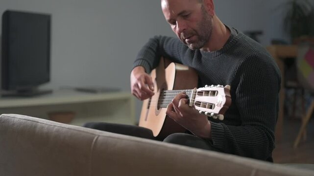 Musician playing classical guitar at home