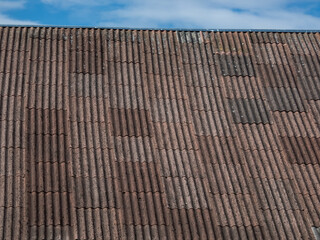 Roof of a building covered with asbestos-containing roofing materials - slates. Material associated with serious illnesses