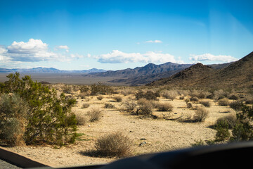 Expansive Desert Valley with Distant Mountain Range Under Blue Sky