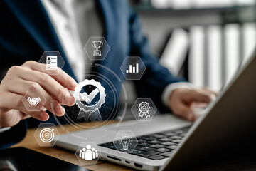 Businesswoman hand touching quality assurance icon with modern technology digital interface, quality control system and business standard management concept on virtual screen, improvement strategy.