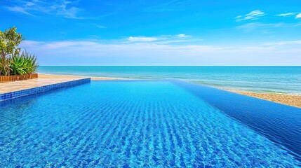 Fototapeta premium Infinity pool meets calm turquoise sea under bright blue sky