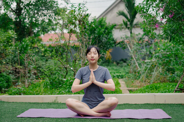 Meditating in a serene garden surrounded by lush greenery during a peaceful afternoon