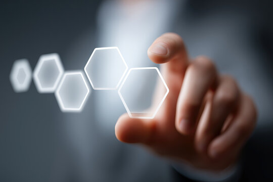 
Hand interacts with glowing hexagonal digital interface elements.