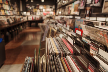 A close-up view of neatly organized vinyl records in a vintage-style music store. The records are categorized with labeled dividers, creating an inviting and nostalgic atmosphere. 