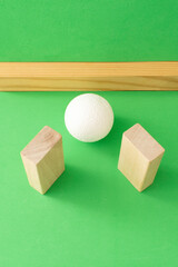 Still life with wooden blocks and a a plastic foam ball on green background