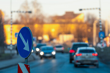 Traffic flows through city streets with clear signage during sunset hours