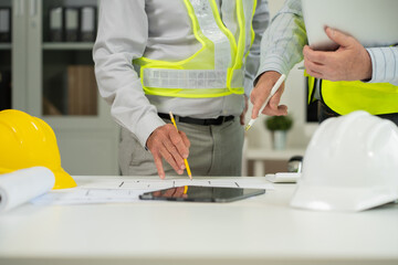 Engineering team collaborates on blueprint and project planning.