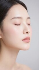Obraz premium A person with closed eyes and a neutral expression against a plain background