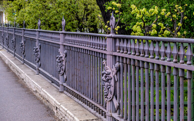 A long antique cast-iron fence. an iron fence.