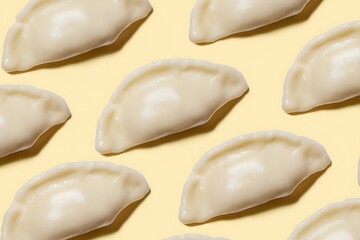 Pattern of uncooked pierogi dumplings on yellow