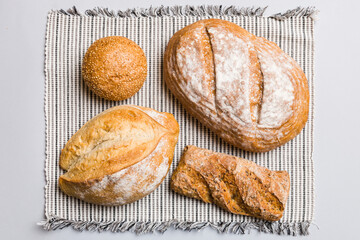 Assortment of freshly baked bread with napkin on rustic table top view. Healthy unleavened bread. French bread
