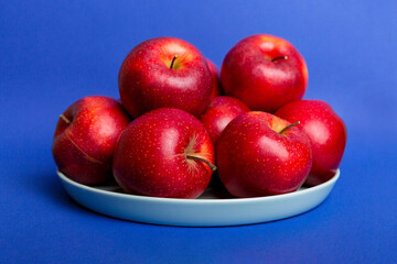 juicy red apples in a bowl or plate on the table top view. Copy space