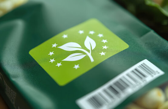 Close-up of EU-Bio-Siegel logo on green food packaging. Organic product certification mark of European Union. White stars around plant leaf symbol. German organic food approved stamp. Product
