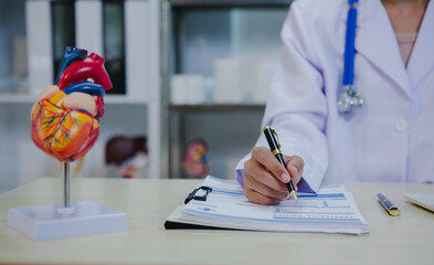 An Asian female specialist attentively consults a patient, discussing symptoms and treatment options with care. She listens closely, offering professional medical advice and support in a calm