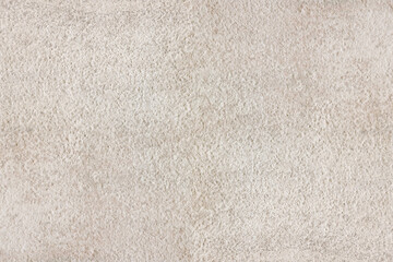 Rough textured surface of beige concrete wall. Plain aged minimal background with copy space in warm tones.