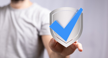 High-quality image of a person holding a shield with a check mark, representing security and data...