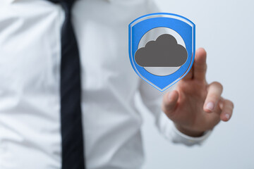 Image of a businessman interacting with a digital shield protecting cloud data, symbolizing...