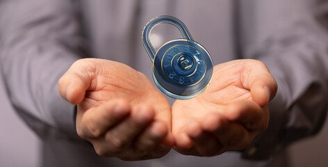 Concept of data protection and cybersecurity.  A digital lock floats above open hands.