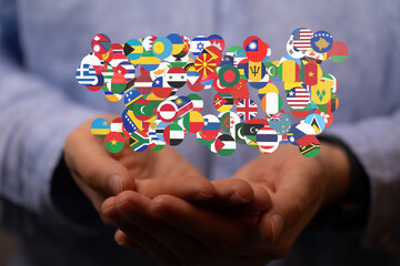 Image of hands gently cradling numerous flags, symbolizing global unity and international...