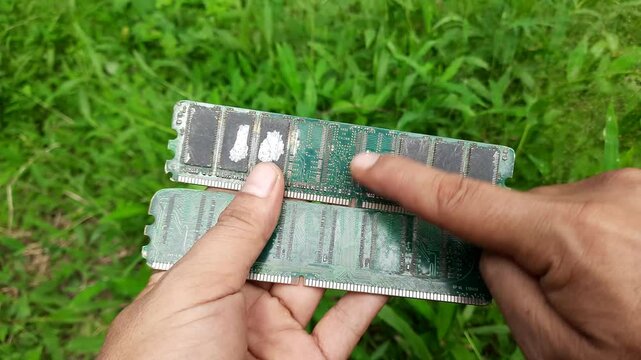 Hands Holding Tarnished Vintage RAM Modules with Visible Chips