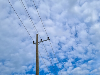 Network of electric cables on power poles with blue sky in the afternoon