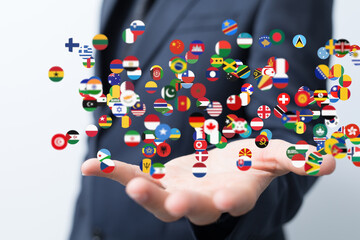 Hand holding numerous flags representing global connections and international business.