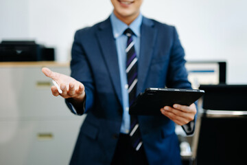 Smiling businessman in suit holds smartphone while gesturing to interact, symbolizing fintech, mobile app UX, innovation, and digital communication