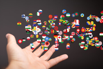 Image of a hand with many flags representing global connections and international collaboration.