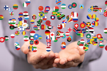 Image of hands gently cradling numerous flags representing global unity and international...