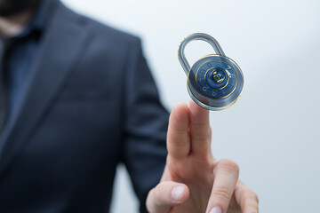 Secure your data.  Cybersecurity concept image of a businessman controlling a digital lock.
