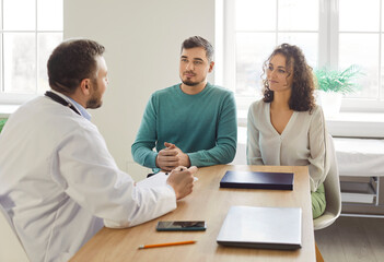 Plakat Doctor consulting couple at clinic, asking, writing medical records, filling patient information file, talking to husband and wife, giving optimistic consultation on reproductive health, planning