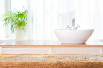 Wooden table top for product presentation on blurred bathroom window interior background