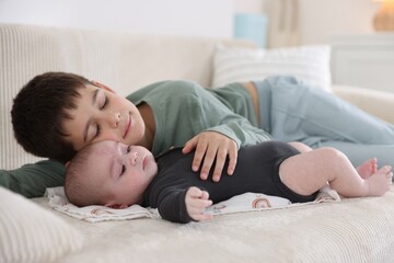 Cute little brothers on sofa at home