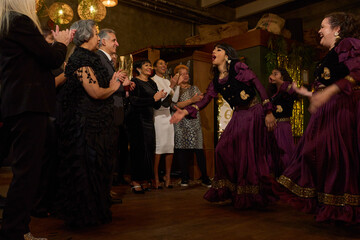 People attending dance show at 60th birthday party at nightclub