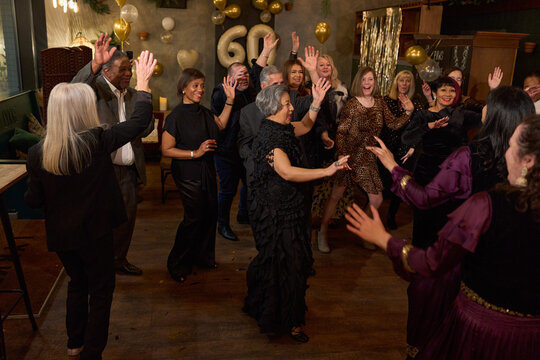 People attending dance show at 60th birthday party at nightclub - Powered by Adobe