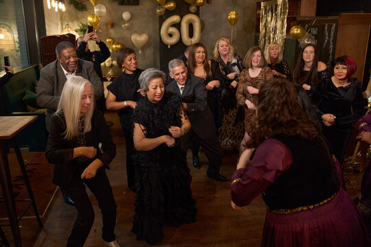 People attending dance show at 60th birthday party at nightclub
