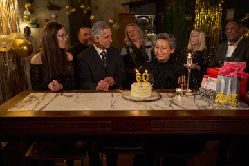 People with birthday cake at 60th birthday party at nightclub