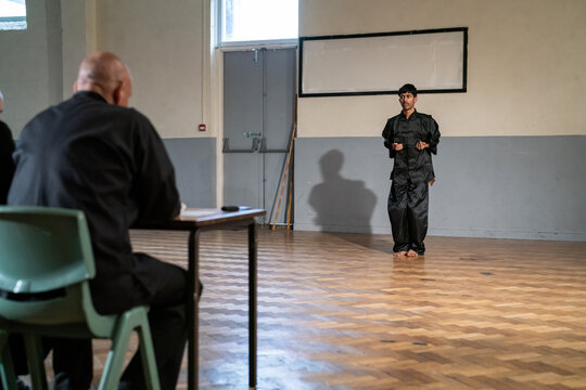 Man performing in front of coach during Kung Fu Black Belt test