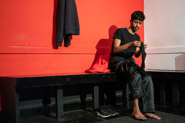 Man putting on socks in gym