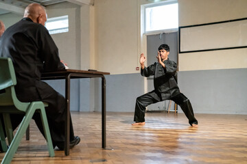 Man performing in front of coach during Kung Fu Black Belt test